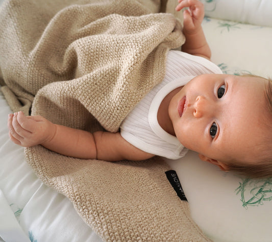 Baby in a beige merino baby blanket