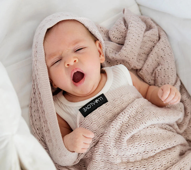Baby in a dusky pink cellular blanket