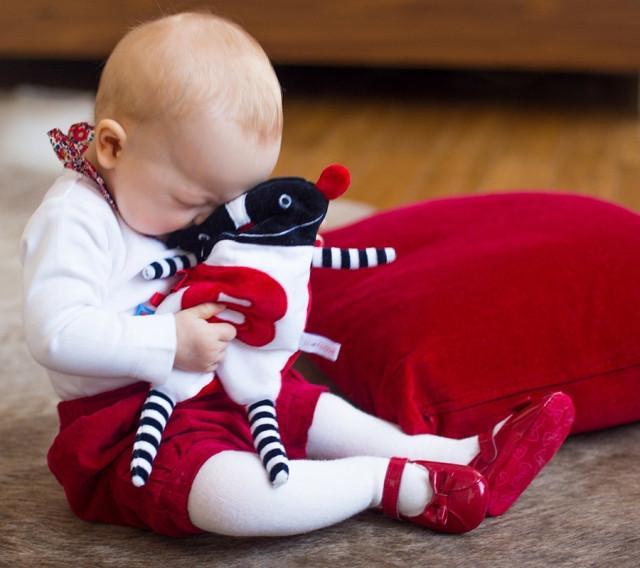 Baby cuddled up with sensory toy