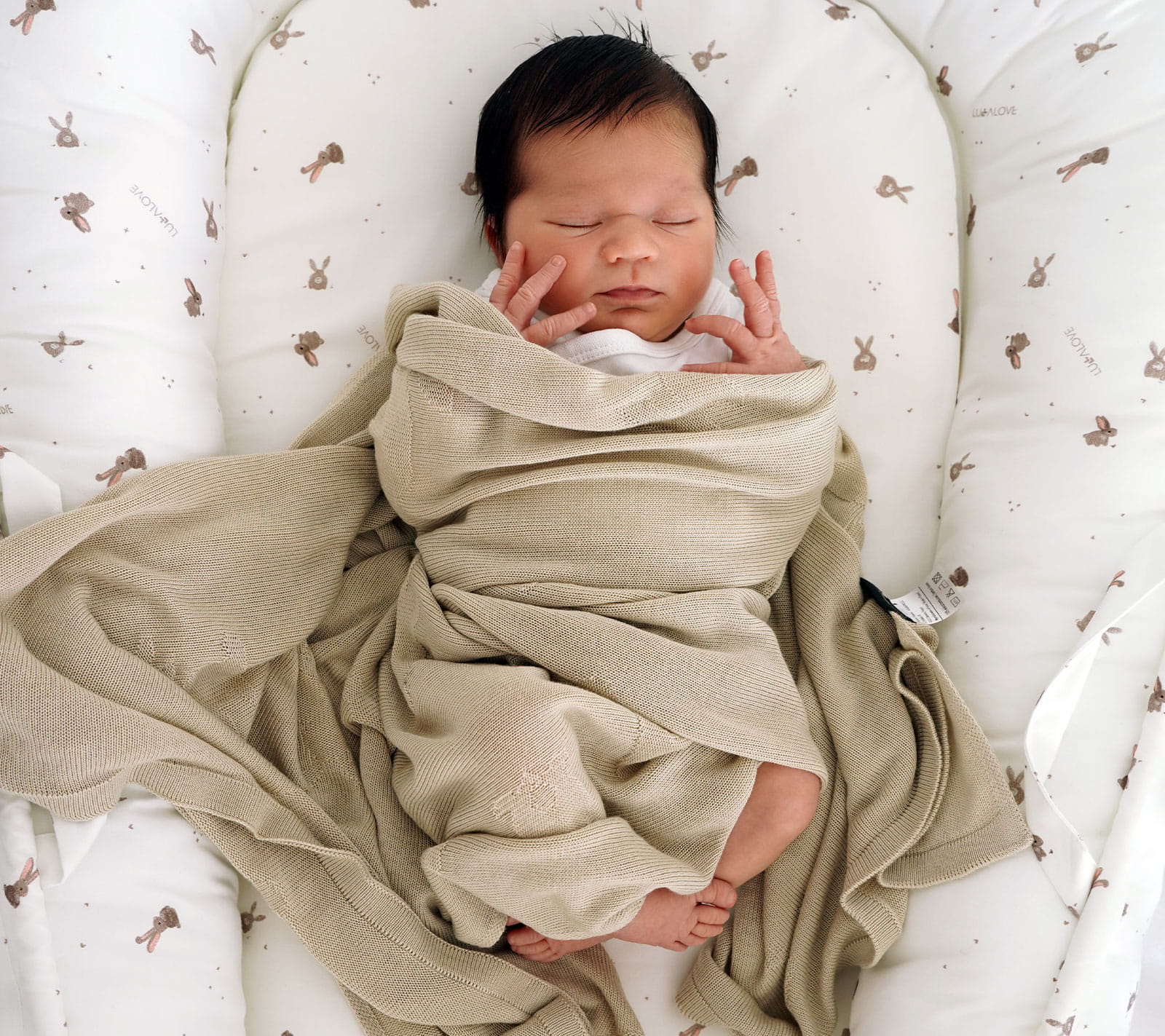 Baby in a beige bamboo baby blanket